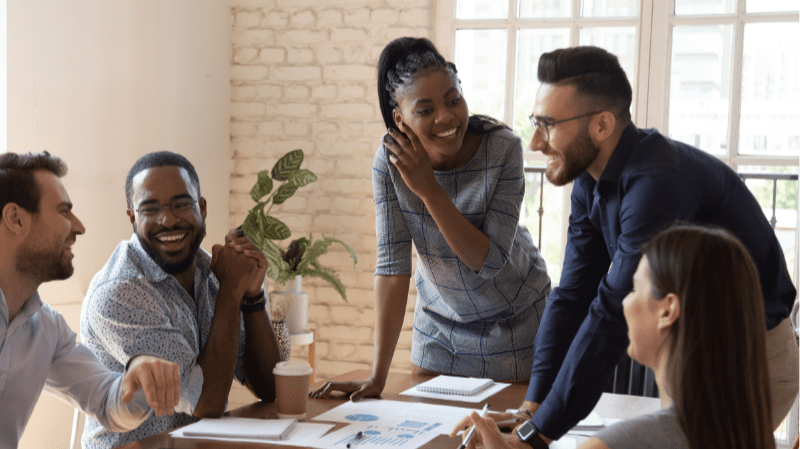 A group of professionals laughing during a meeting.