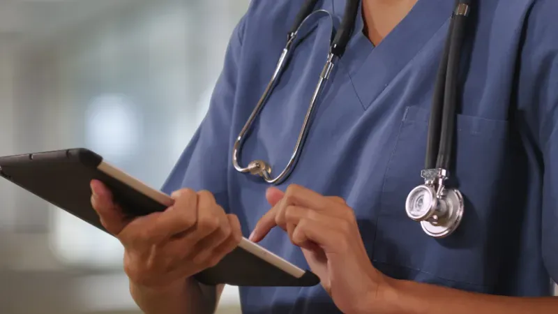 Travel nurse looking at a report on their iPad.