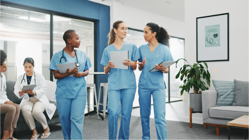 A group of nurse friends smiling and walking together.