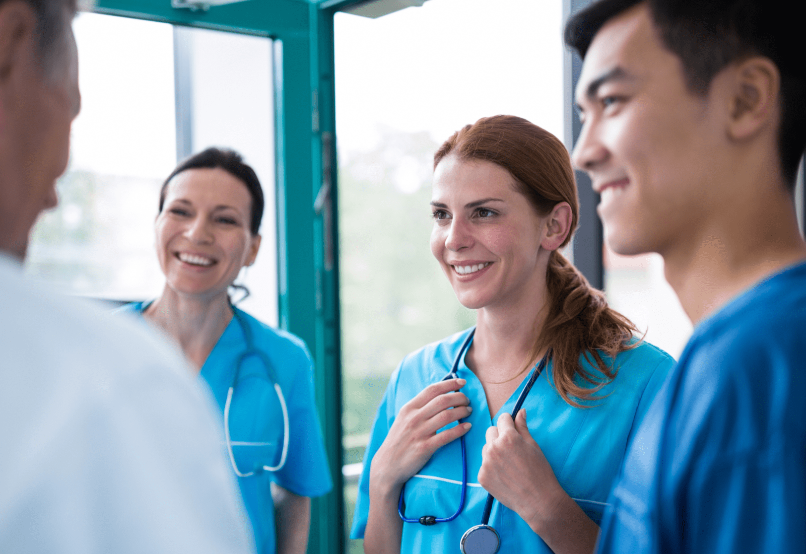 Group of travel nurses talking and smiling.